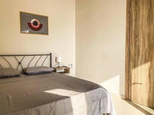 1 dormitorio con 1 cama y una foto en la pared en Poseidon’s Bayview, en Kitriaí