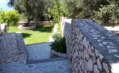 a stone retaining wall with a garden in a yard at The Cerulean Villa - The Concord Of Blue And Green in Mousata