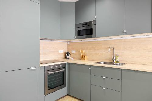 une cuisine avec des armoires blanches et un évier dans l'établissement Cozy renovated apartment - close to Martinez Hotel, à Cannes