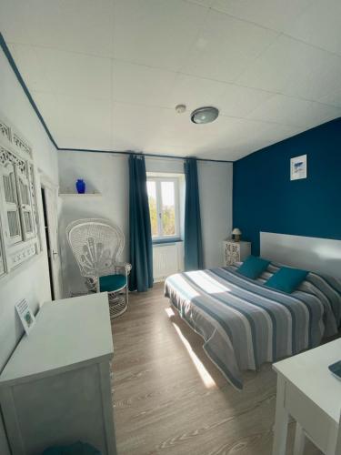 um quarto com paredes azuis e uma cama com almofadas azuis em Les forges de Planechaud em Saint-Sornin-Leulac