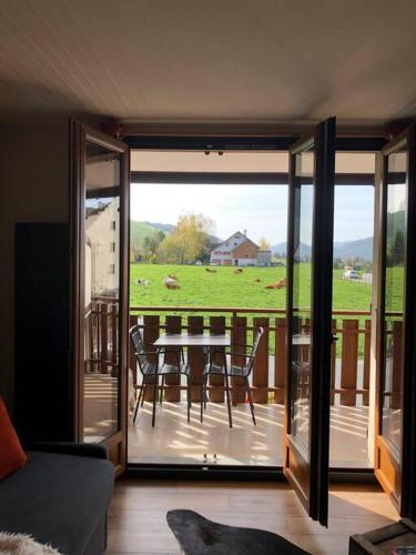 une chambre avec un balcon avec une table et des chaises dans l'établissement Studio Beethoven, à Lans-en-Vercors