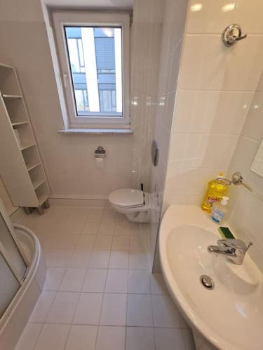 La salle de bains blanche est pourvue d'un lavabo et de toilettes. dans l'établissement 10Q - Z6 Apartment 306, à Varsovie