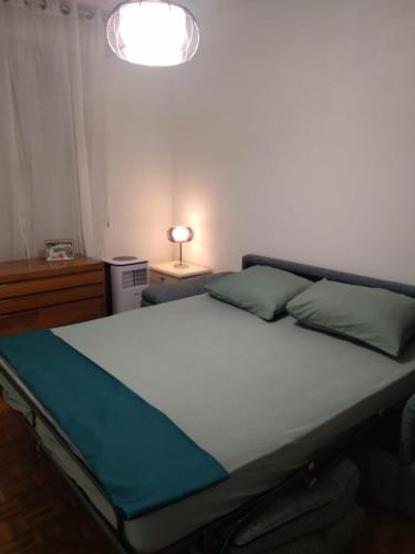 a bed in a bedroom with a lamp on a table at Mini apartment close to everything you will need in Pasian di Prato