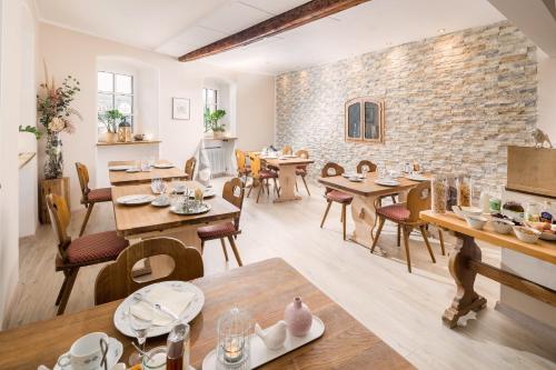 a dining room with tables and chairs and a brick wall at Landhotel Löwen in Erlabrunn