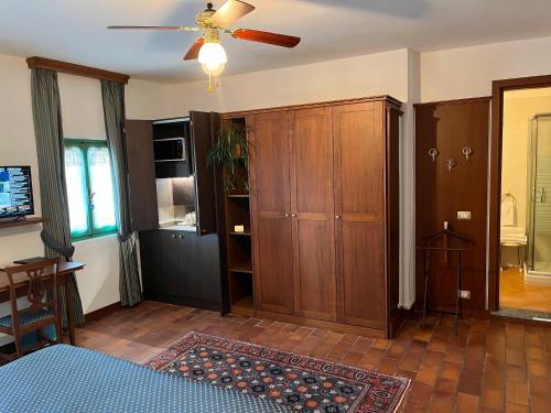 una sala de estar con un gran armario de madera y un ventilador en Casa Violetta B&B, en Agrate Conturbia