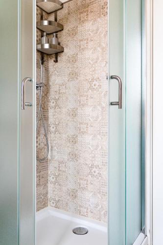 a shower with a glass door next to a tub at Myro's House in La Spezia