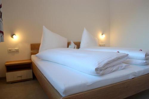 施特格的住宿－Ferienwohnungen Anja，一张白色大床,配有白色床单和枕头