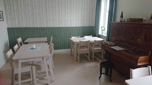 a dining room with two tables and a piano at STF Vandrarhem Blentarp in Blentarp