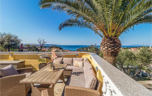 a patio with a table and a palm tree at Beautiful Home In Banjol With Sauna in Banjol