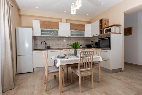 una cocina con electrodomésticos blancos, mesa y sillas en Calypso - newly equiped, with separate entrance and parking, en Supetar