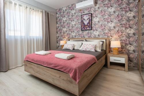 a bedroom with a large bed with a red blanket at Calypso - newly equiped, with separate entrance and parking in Supetar