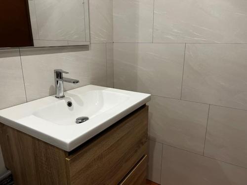 ein Badezimmer mit einem weißen Waschbecken und einem Spiegel in der Unterkunft Appartement 6-8 pers, proche mer in Linguizzetta