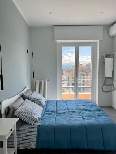 1 dormitorio con cama azul y ventana grande en Testa tra le Nuvole en Novi Ligure