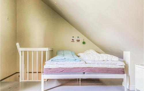 1 dormitorio con cuna y 1 cama en el ático en 3 Bedroom Nice Home In Burgsvik, en Burgsvik