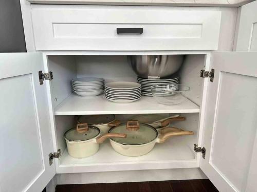 a cabinet filled with dishes and plates in a kitchen at Secret Escape 20 Min from NYC N 1 in Jersey City