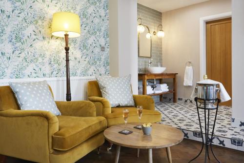 uma sala de estar com um sofá e uma mesa em The Old New Inn em Bourton on the Water