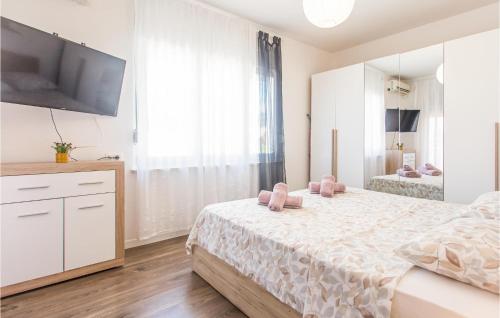 una camera bianca con letto e TV a schermo piatto di Awesome Apartment In Kastel Kambelovac With Wifi a Kaštela (Castelli)