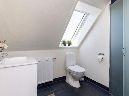 a bathroom with a toilet and a window at Holiday home Læsø II in Læsø