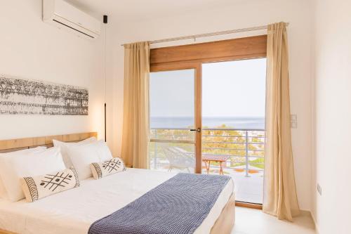 a bedroom with a bed and a large window at Villa Santa Maria with private pool and sea view in Afantou