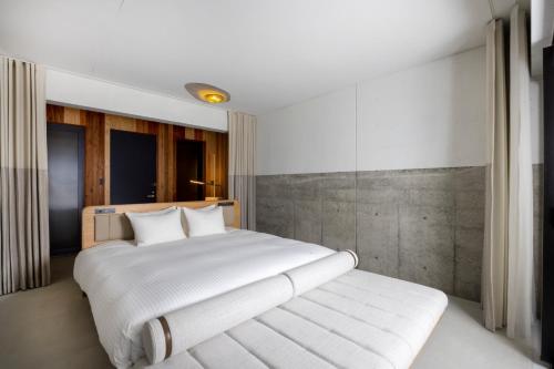 a bedroom with a large white bed with white pillows at Izumo HOTEL THE CLIFF in Kumura