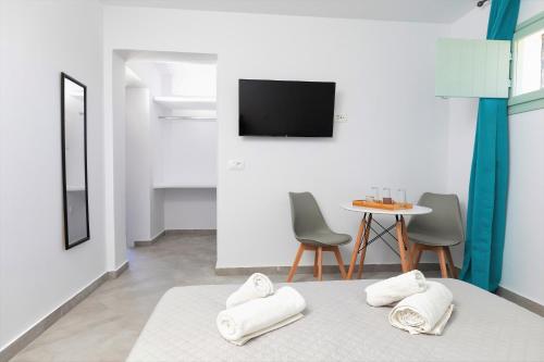 um quarto com uma cama e uma mesa com cadeiras em White Element em Karterados