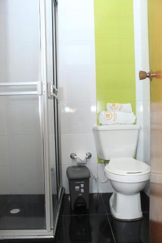 a small bathroom with a toilet and a shower at Suna Bacata in Bogotá