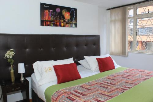 a bedroom with a large bed with a black headboard at Suna Bacata in Bogotá
