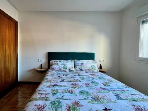 una camera da letto con un grande letto con un copriletto colorato di Ático en el centro recién reformado a Oviedo