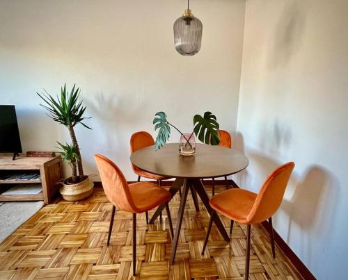 una sala da pranzo con tavolo e 4 sedie di Ático en el centro recién reformado a Oviedo