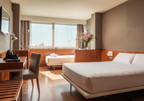 Habitación de hotel con cama y escritorio en Hotel SB BCN Events 4* Sup, en Castelldefels
