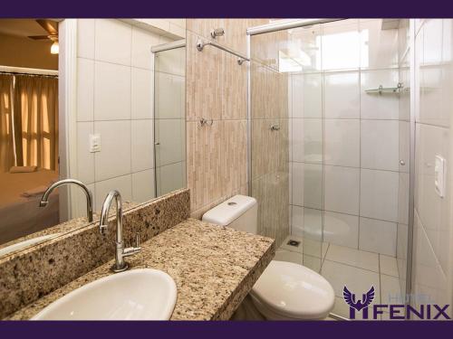 a bathroom with a sink and a toilet and a shower at Hotel Fenix in Assis