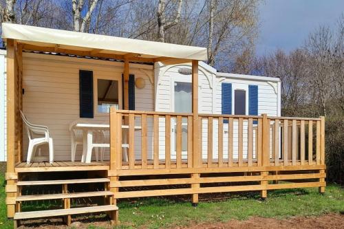 a tiny house with a porch and a gazebo at Mobil home au bord du lac in Nages