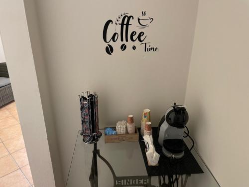 a glass table with a coffee time sign on a wall at Rent room Iacopo in Capannori