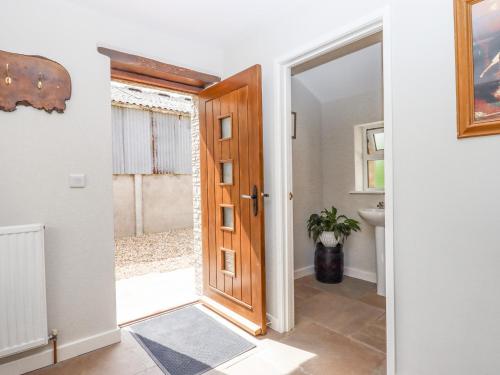 a door leading to a bathroom with a sink at Bunts Barn in Okehampton