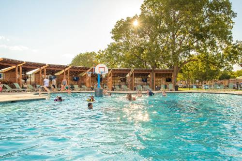 a group of people playing in a swimming pool at Camp Fimfo Waco in Waco