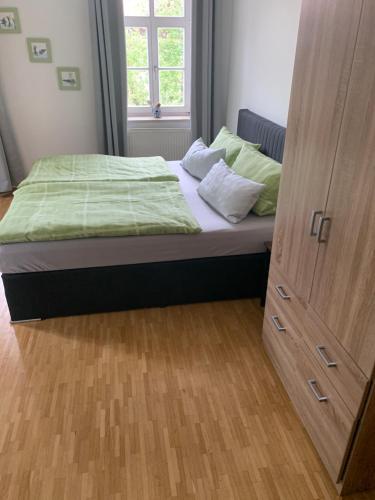 ein Schlafzimmer mit einem Bett und einem Schrank in der Unterkunft Gasthaus Franz Inselkammer in Höhenkirchen-Siegertsbrunn