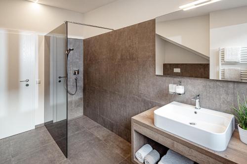 a bathroom with a sink and a shower at Prälatenhof Wine & Apartments in Caldaro