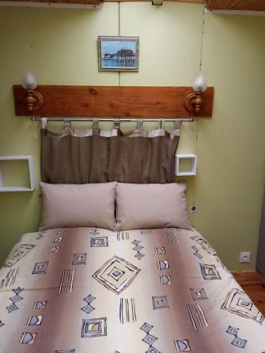 a bedroom with a bed with a wooden headboard at La cabane in Palogneux