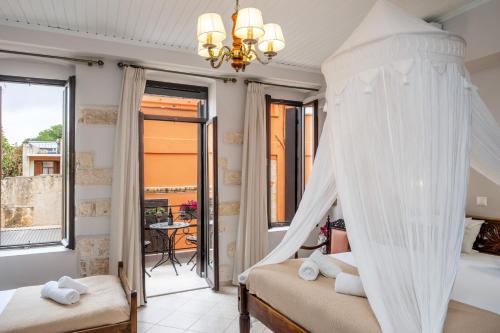 a bedroom with a canopy bed and a balcony at Santa Elena Boutique Rooms in Chania