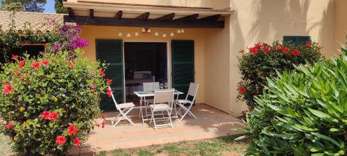 eine Terrasse mit einem Tisch, Stühlen und Blumen in der Unterkunft Casita Vista Mar Duplex - Son Xoriguer in Son Xoriguer