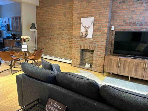 a living room with couches and a brick wall at Liberty Dream - 20 min to NYC in Jersey City