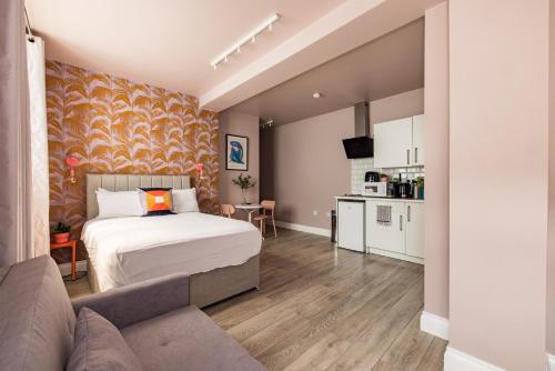 een slaapkamer met een bed en een bank en een keuken bij Euston apartments in Londen