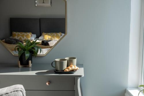 a bedroom with a bed with a mirror and a table at Cozy House with Modern Garden in Great Yarmouth
