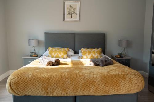 a bedroom with a large bed with two towels on it at Cozy House with Modern Garden in Great Yarmouth