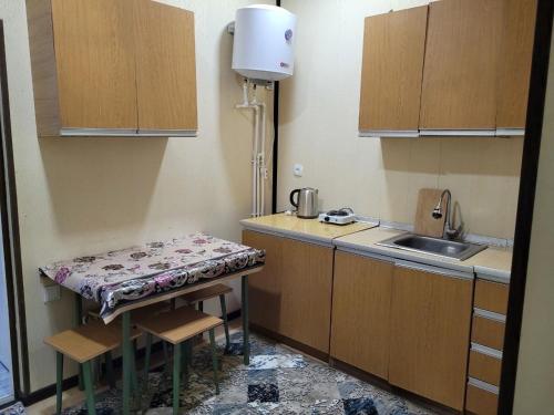 a small kitchen with a table and a sink at UZUMZOR HOUSE in Aktepa-Chigatay