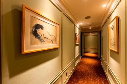 a hallway with paintings on the walls at Signature by M Village Hai Bà Trưng in Ho Chi Minh City