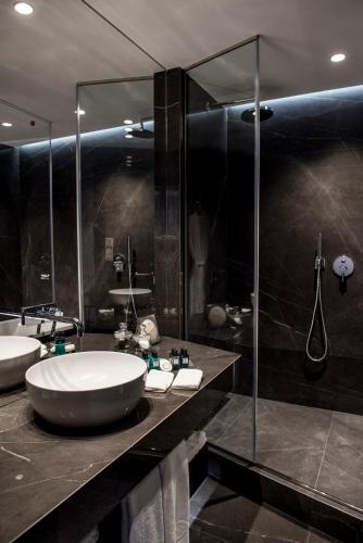 a bathroom with two sinks and a glass shower at Sofitel Athens Airport in Athens
