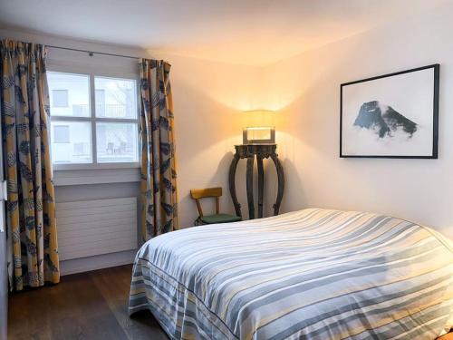 a bedroom with a bed and a window at 4 1/2 Room Maisonette Apartment with great views in Sils Maria