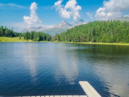 a dock on a lake with mountains in the background at 4 1/2 Room Maisonette Apartment with great views in Sils Maria