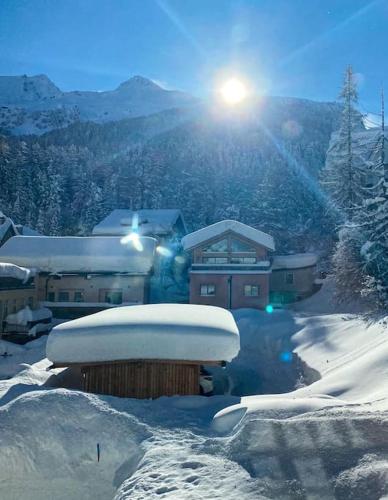 a snow covered building with the sun in the background at 4 1/2 Room Maisonette Apartment with great views in Sils Maria